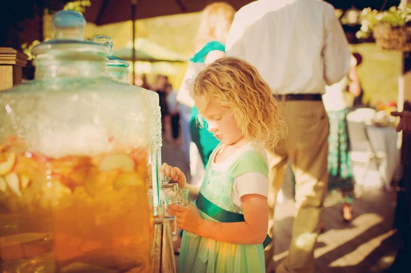 a little girl getting a drink from the dispenser