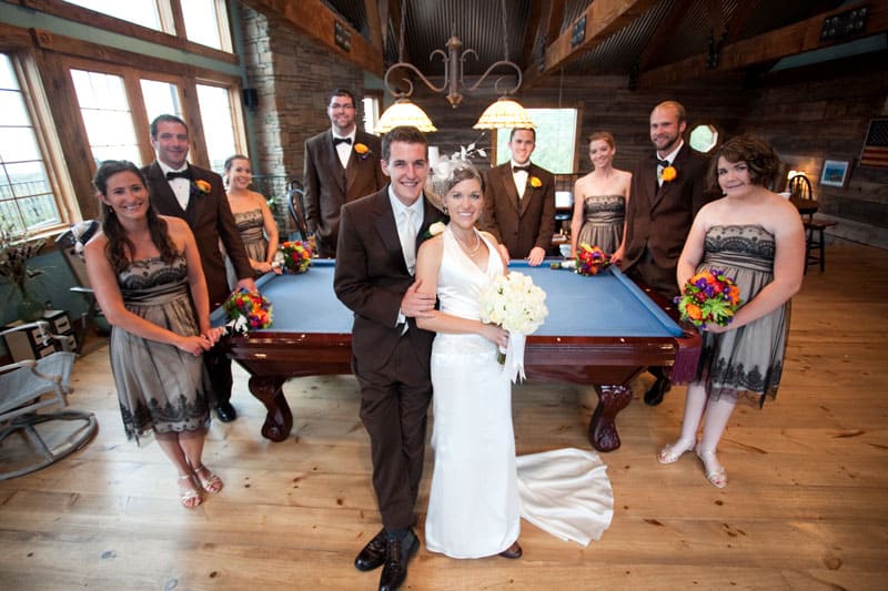 bride and groom with friends taking picture by the pool table