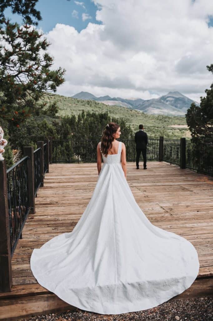 a back view of a bride with the groom on the extreme end of the walkway